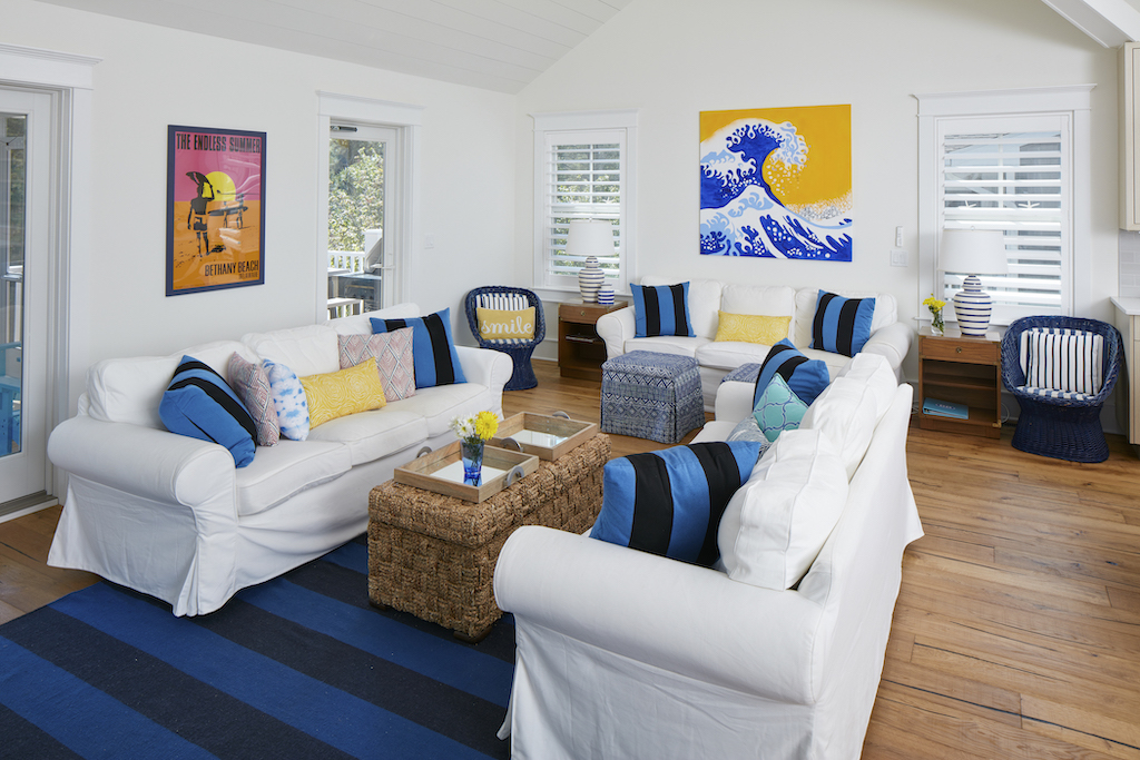 The Big Easy family room opposite view with bright yellow and blue wave painting