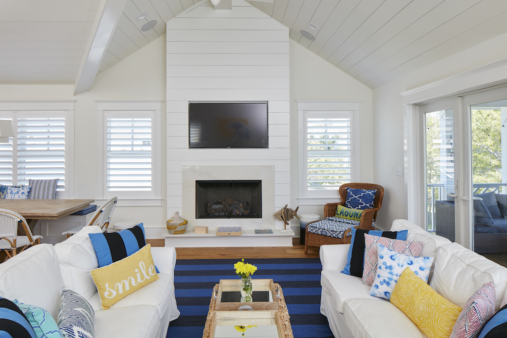 The Big Easy family room with flatscreen TV over fireplace, and two white sofas