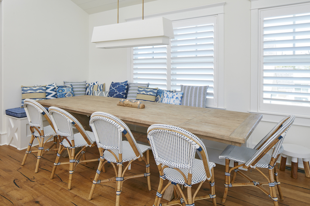 The Big Easy dining table with throw pillows and white chairs